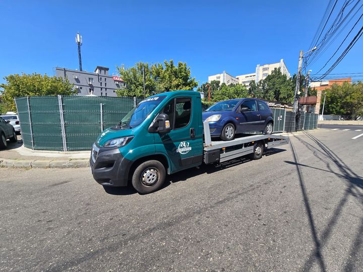 Tractare auto în București: hatchback albastru pe autoplatformă